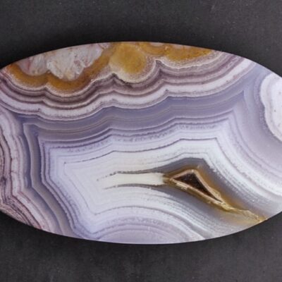 A white and purple agate on a black surface.