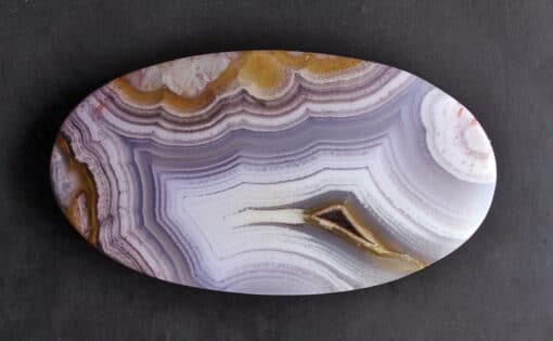 A white and purple agate on a black surface.