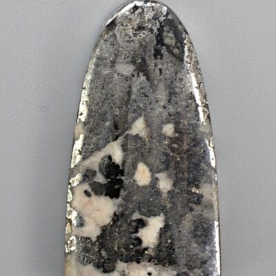 A black and white stone pendant on a white surface.