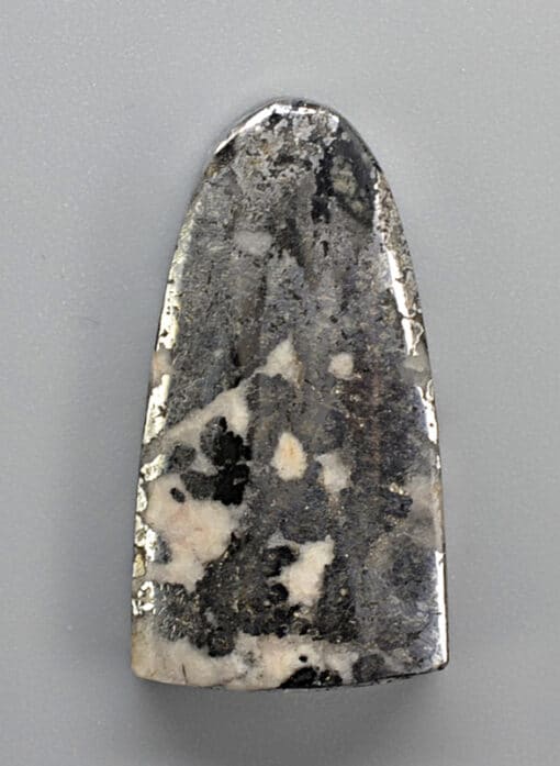 A black and white stone pendant on a white surface.