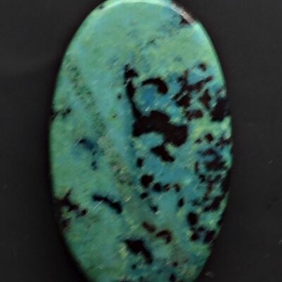 An oval turquoise stone on a black background.