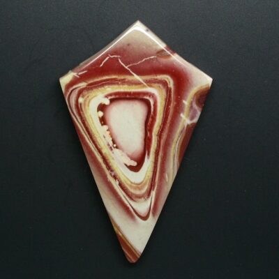 A piece of red and yellow agate on a black surface.