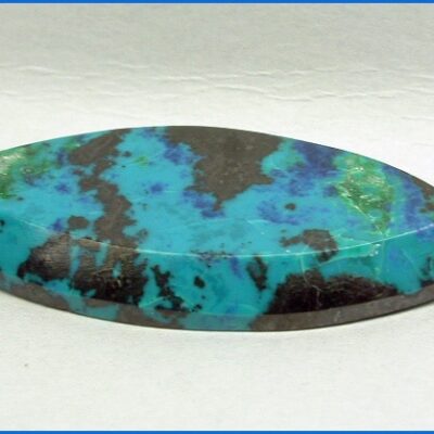 A turquoise and black leaf shaped pendant on a white background.