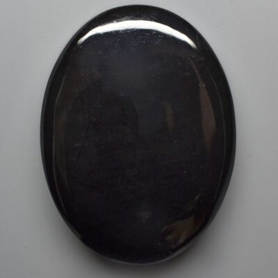 A black stone on a white surface.