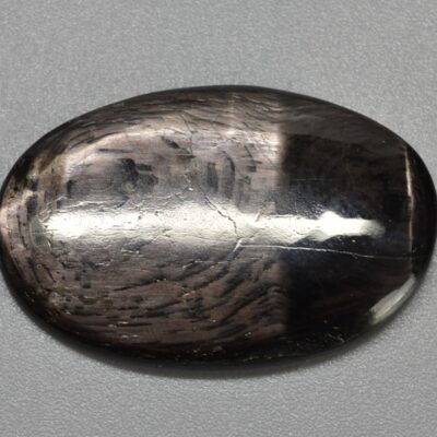 A black stone on a grey surface.