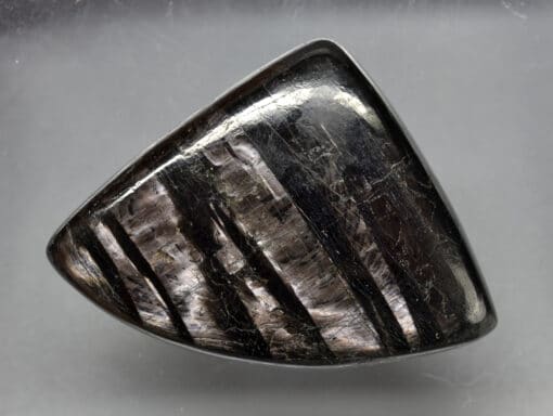 A black stone with black stripes on it.