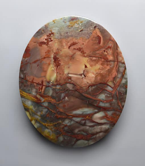 A round piece of marble with brown and orange swirls on it.