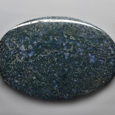 A green jasper stone on a white surface.