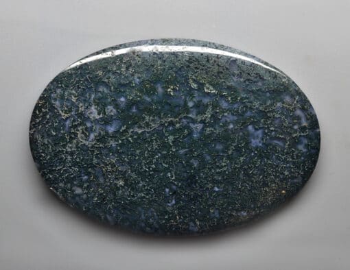 A green jasper stone on a white surface.