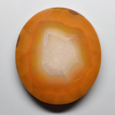 An orange and white agate plate on a white surface.