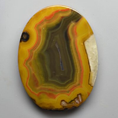 A yellow and white agate on a white surface.