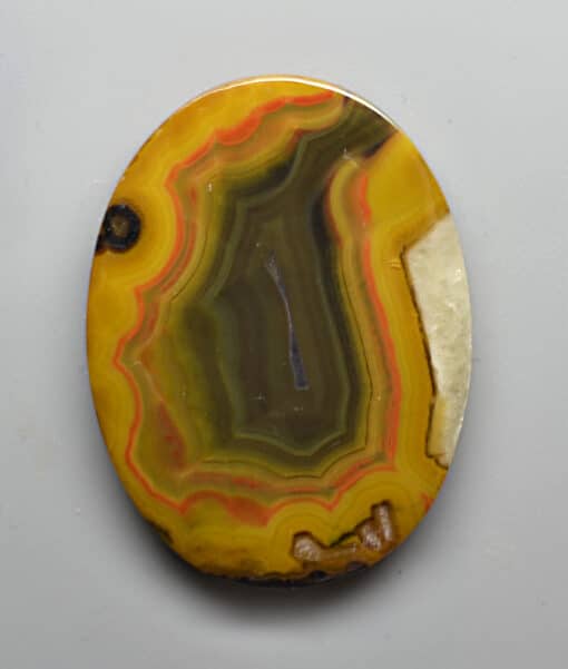 A yellow and white agate on a white surface.