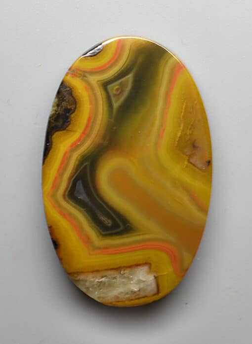 A yellow and white agate on a white surface.