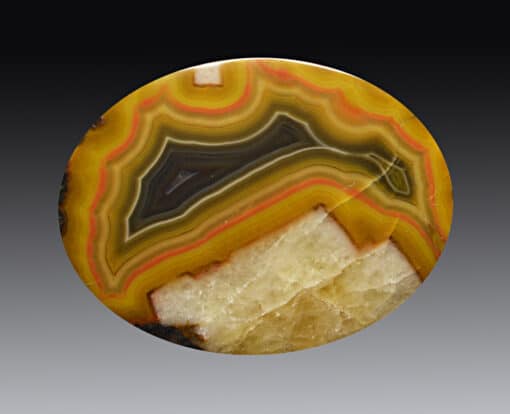 A round piece of agate with a yellow and orange pattern.
