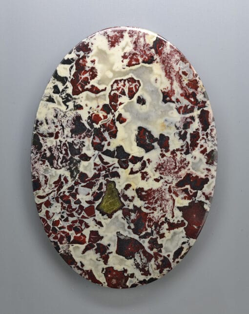 A red and white marble plate on a white surface.