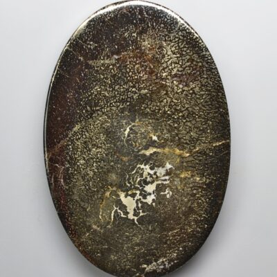 An oval shaped piece of stone on a white surface.