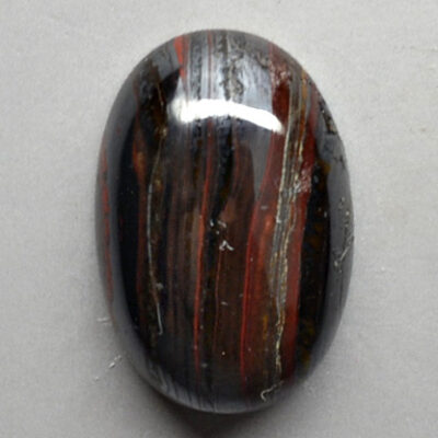 A black and brown striped stone on a white surface.
