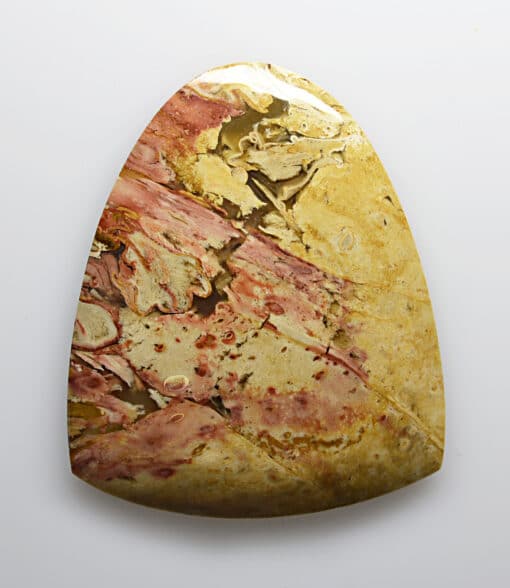 A piece of yellow and brown stone on a white surface.
