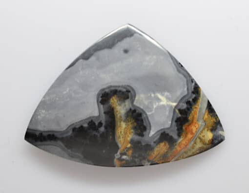 A triangular piece of agate on a white surface.
