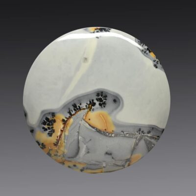 A white, yellow, and black marble disk on a gray background.