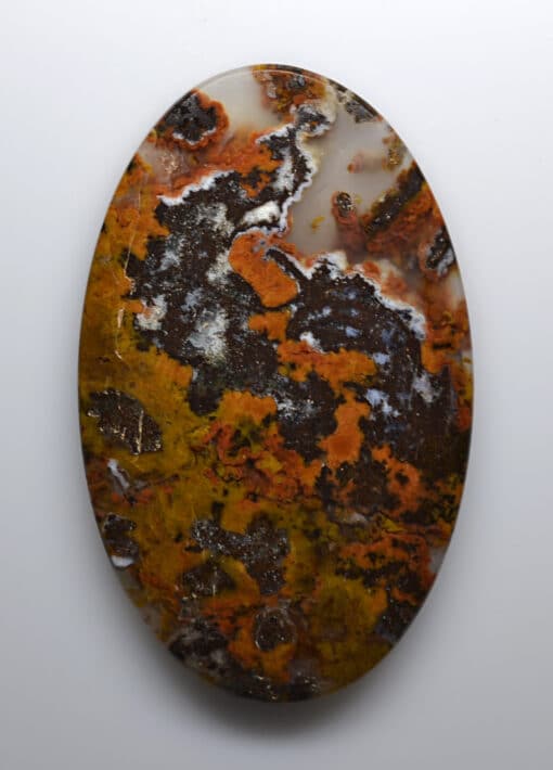 A piece of agate with orange and brown spots on it.