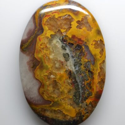A yellow and orange agate stone on a white surface.