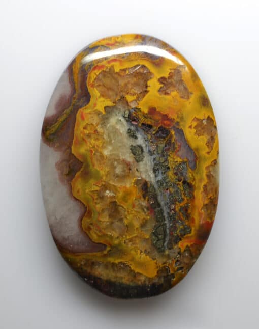 A yellow and orange agate stone on a white surface.