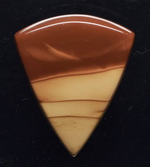 A triangle shaped piece of brown and white marble.