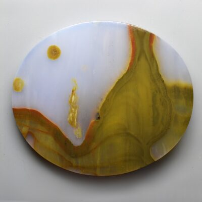 A round piece of agate with yellow and brown swirls.