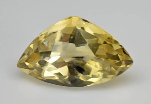A yellow sapphire cut into a triangular shape.