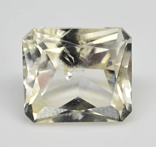 A square cut yellow sapphire on a white background.