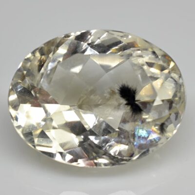 An oval cut yellow sapphire on a white surface.