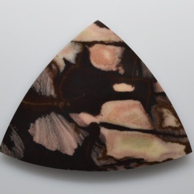 A triangular piece of black and brown marble on a white surface.