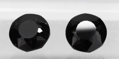 A pair of black diamonds on a white surface.