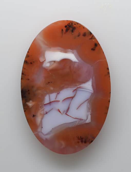 An orange and white agate pendant on a white background.