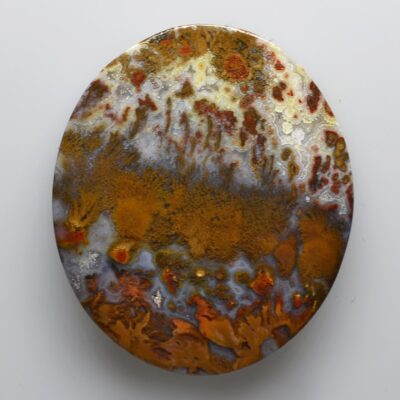 A round plate with orange and brown paint on it.