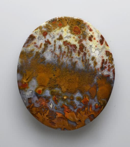 A round plate with orange and brown paint on it.