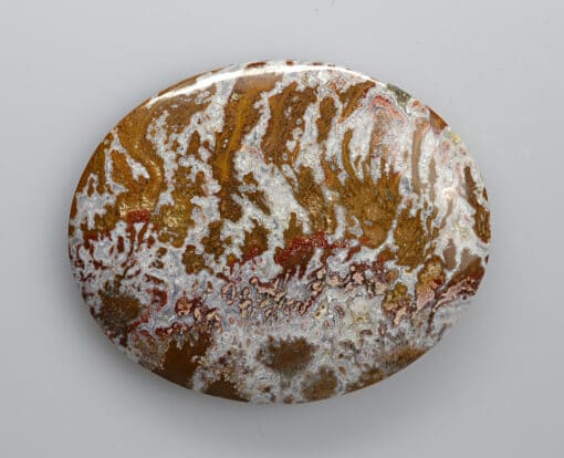 A brown and white marble button on a white surface.