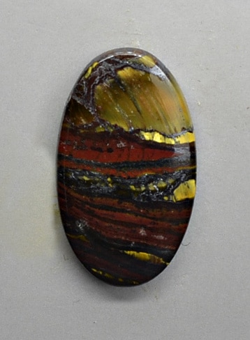 A piece of agate with gold and black stripes.