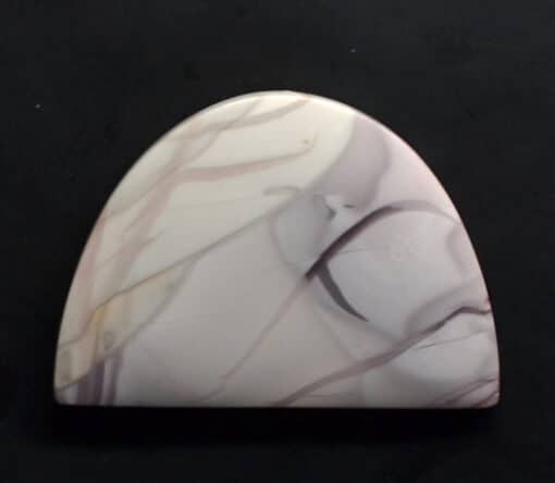 A white and pink marble pendant on a black surface.