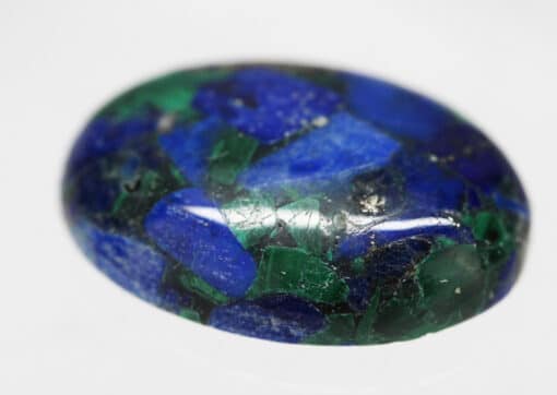 An oval lapis stone on a white surface.