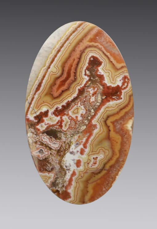 A red and brown agate oval cabochon.