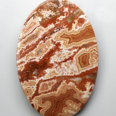 A round piece of red agate on a white background.