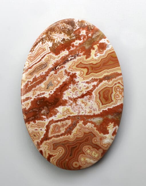 A round piece of red agate on a white background.