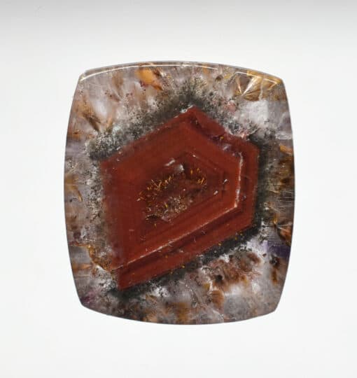 A square piece of red apatite on a white background.