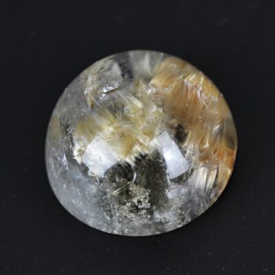A round piece of quartz with a lot of brown and yellow specks on it.