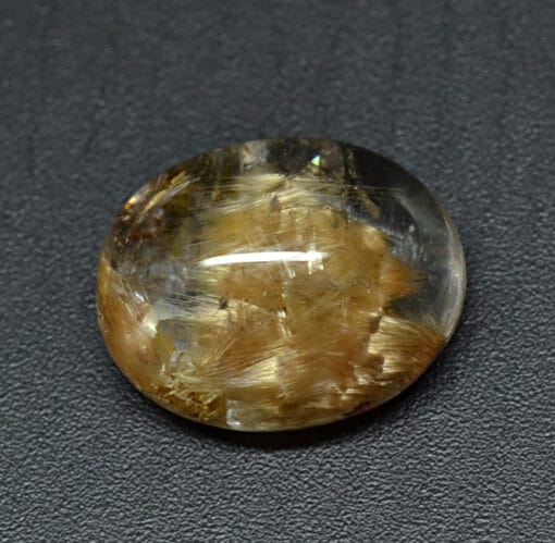 A yellow and brown stone on a black surface.