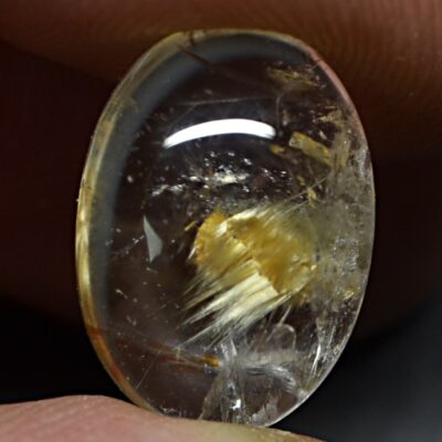 A person holding a piece of yellow quartz.
