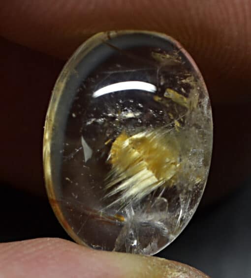 A person holding a piece of yellow quartz.