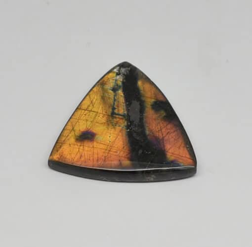 A triangle shaped stone with black and orange spots.